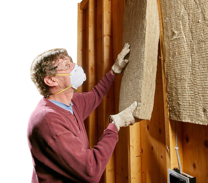 Person installing batt-style acoustic insulation into a wall cavity, wearing safety gear. This soundproofing material aids in noise reduction and vibration damping, aligning with Sound Deadening UK's offerings.